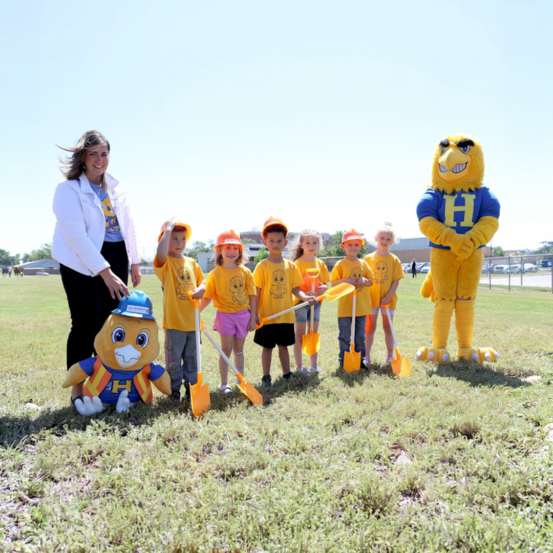 Dr. Krystal Young, left, deputy superintendent of Hutchinson USD 308, and district students break ground on the expanded Lil' Hawks Early Learning Program facility which will nearly triple the number of birth to Pre-K children served by USD 308.